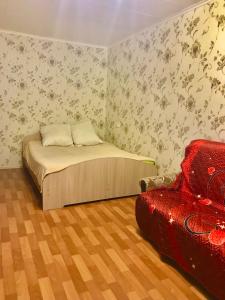 イヴァノヴォにあるОднокомнатная квартира у Академии МЧСのベッドルーム1室(ベッド1台、赤い椅子付)