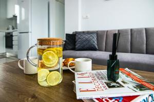 a table with a glass pitcher of lemonade and a book at Phaedrus Living - Seaside Executive Flat Harbour 205 in Paphos