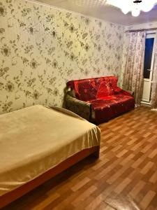 イヴァノヴォにあるОднокомнатная квартира у Академии МЧСのベッドルーム1室(ベッド2台、赤いソファ付)