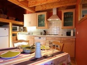 una cocina con armarios de madera y una mesa con mantel. en Gîte Araules, 3 pièces, 4 personnes - FR-1-582-263, en Araules