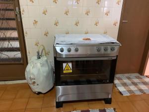 Una estufa en una cocina con una bolsa al lado. en Casa de temporada no centro de arraial do cabo, en Arraial do Cabo