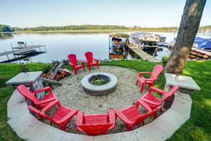een groep rode stoelen rond een vuurplaats bij het water bij Blue Fish Cottage in Waterford +4 foto's