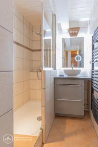 uma casa de banho com um chuveiro e um lavatório. em Résidence Le Pied des Pistes C6 em Lanslevillard