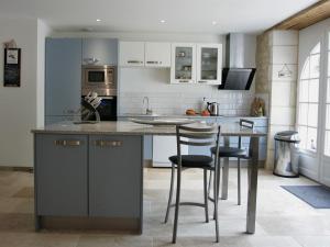 a kitchen with a island with two bar stools at Gîtes du Château Mont d'Onel in Couze-et-Saint-Front