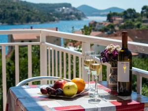 un tavolo con una bottiglia di vino e un piatto di frutta di Apartments Njiric a Zaton