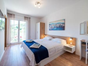 - une chambre avec un lit et une grande fenêtre dans l'établissement Apartments Njiric, à Zaton