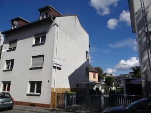 un bâtiment blanc avec une clôture devant lui dans l'établissement Apartment-EG-08, à Darmstadt
