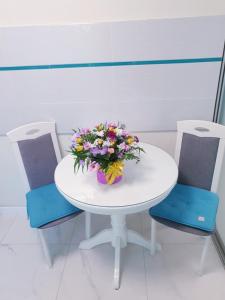 a white table with a bouquet of flowers on it at Tiffany apartment in the center in Dnipro +3 photos