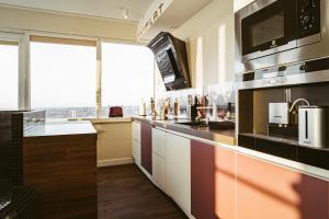 a kitchen with a counter top with a microwave at sky FLAT jacuzzi sauna 27 FLOOR in Klaipėda