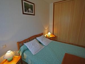 ein Schlafzimmer mit einem grünen Bett mit zwei Lampen in der Unterkunft Gîte Gérardmer, 3 pièces, 4 personnes - FR-1-589-124 in Gérardmer