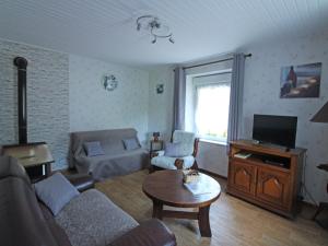 a living room with a couch and a tv at Gîte Cornimont, 3 pièces, 5 personnes - FR-1-589-70 in Cornimont