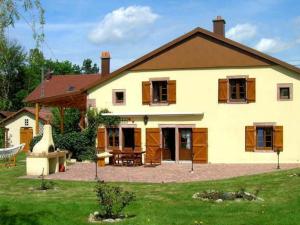 een groot wit huis met een patio en een tuin bij Gîte Granges-Aumontzey-Granges-sur-Vologne, 3 pièces, 5 personnes - FR-1-589-122 in Granges-sur-Vologne