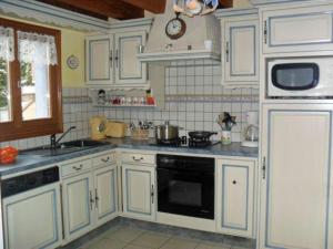 een keuken met witte kasten en een fornuis met oven bij Gîte Ferdrupt, 3 pièces, 6 personnes - FR-1-589-146 in Ferdrupt