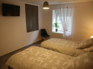 1 dormitorio con 2 camas, ventana y TV en Gîte Fléville-Lixières, 4 pièces, 6 personnes - FR-1-584-166, 