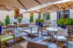 a patio with tables and chairs and umbrellas at UNAWAY Hotel Empire Roma in Rome