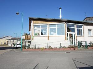 a white building with large windows on a street at Charmant apt avec accès indépendant, terrasse, proche Épinal et activités culturelles - FR-1-589-138 in Hagécourt