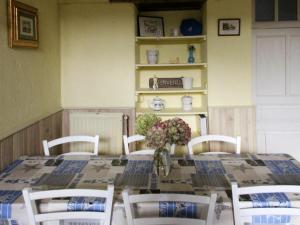 - une table à manger avec un vase de fleurs dans l'établissement Gîte Saint-Christophe-du-Ligneron, 3 pièces, 5 personnes - FR-1-426-258, à Saint-Christophe-du-Ligneron