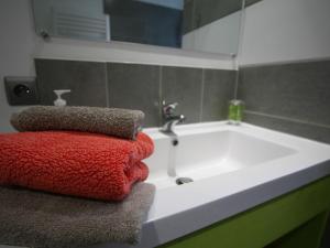 W łazience znajduje się biała wanna i czerwone ręczniki. w obiekcie Gîte Vincey, 2 pièces, 2 personnes - FR-1-589-262 w mieście Vincey