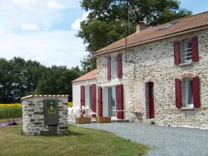 - un vieux bâtiment en pierre avec des volets rouges dans l'établissement Gîte La Roche-sur-Yon, 5 pièces, 10 personnes - FR-1-426-157, à La Roche-sur-Yon