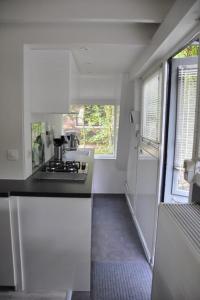a white kitchen with a stove and a window at Vakantiehuis Durbuy 'De witte vlinder' in Durbuy