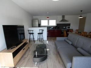 ein Wohnzimmer mit einem grauen Sofa und einer Küche in der Unterkunft Gîte Combrimont, 3 pièces, 4 personnes - FR-1-589-367 in Combrimont