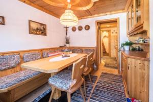 a dining room with a wooden table and chairs at Hochfügenblick-erholung für Zwei in Hochfugen
