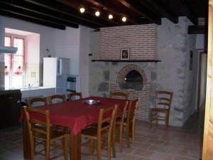 une salle à manger avec une table et une cheminée en briques dans l'établissement Gîte Cravant, 4 pièces, 6 personnes - FR-1-590-21, à Cravant