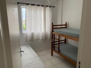 Apart Home Águas de Porto Belo في بورتو بيلو: غرفة بسريرين بطابقين ونافذة