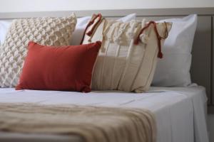 a bed with four pillows on top of it at Fontes da Pipa by Liiv Rooms in Pipa