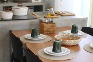a wooden table with plates and hats on it at Fontes da Pipa by Liiv Rooms in Pipa