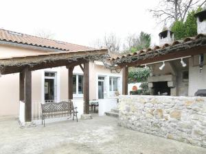 Maison avec piscine privée et jardin à 5 min du Puy-en-Velay, idéale pour découvrir la Haute-Loire - FR-1-582-320 في Espaly-Saint-Marcel: مقعد يجلس خارج منزل به جدار حجري