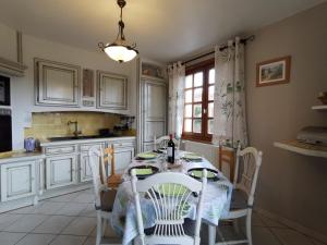 cocina blanca con mesa, sillas y ventana en Gîte Saint-Germain-Laprade, 4 pièces, 6 personnes - FR-1-582-322 en Saint-Germain-Laprade