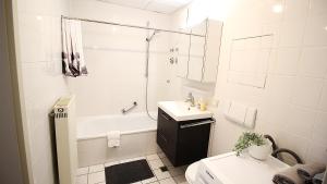 a white bathroom with a tub and a sink and a toilet at Ruhe im Zentrum Privatparkplatz&Panorama-Erker in Würzburg