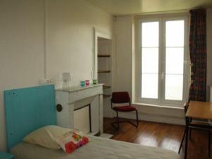 - une chambre avec un lit, une cheminée et une chaise dans l'établissement Gîte Toul, 4 pièces, 7 personnes - FR-1-584-74, à Toul