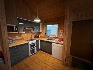 cocina con paredes de madera y suelo de madera en Fern Lodge, en Dallavich