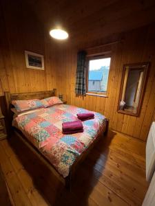 ein Schlafzimmer mit einem Bett in einer Holzhütte in der Unterkunft Fern Lodge in Dalavich