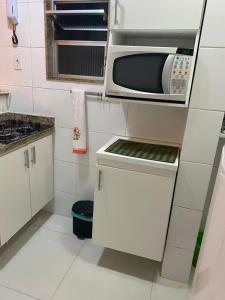a small kitchen with a microwave and a stove at Copacabana Apartment in Rio de Janeiro