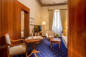 um quarto de hotel com um sofá e uma sala de estar em UNAWAY Hotel Empire Roma em Roma