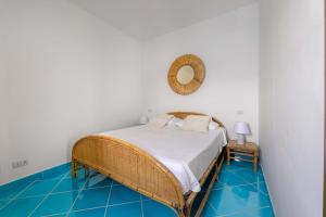 a bedroom with a wicker bed and blue tiled floors at Maison del sole in Massa Lubrense