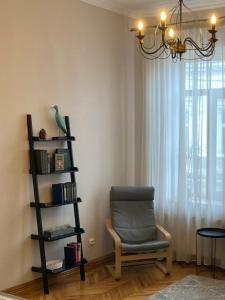ein Wohnzimmer mit einem Stuhl und einem Kronleuchter in der Unterkunft Квартира в центрі Тернополя in Ternopil