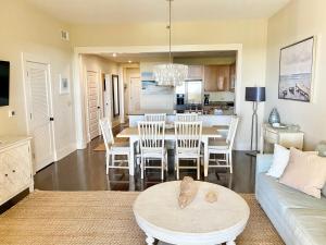 a living room with a couch and a table with chairs at 30A! Redfish Village Unit M2-424 is in the heart of it all!! in Santa Rosa Beach