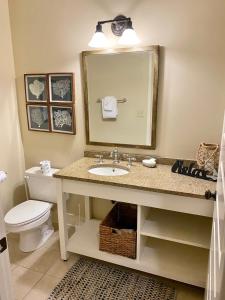 a bathroom with a sink and a toilet and a mirror at 30A! Redfish Village Unit M2-424 is in the heart of it all!! in Santa Rosa Beach