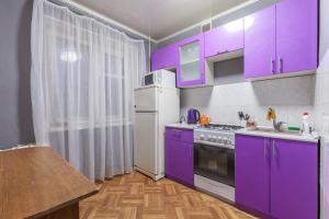 トリヤッチにある1-комнатная квартираのキッチン(紫色のキャビネット、白い冷蔵庫付)