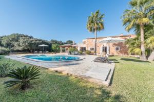een villa met een zwembad en palmbomen bij Finca Ca'n Puig in Calonge