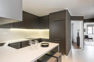 a kitchen with black cabinets and wine glasses on a counter at Executive 2 bdr Suite in Plaka - Acropolis view in Athens