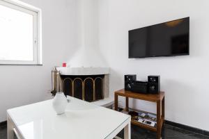 a living room with a tv and a fireplace at An adorable Apartment in Athens in Athens