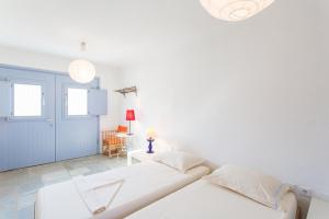 RámosにあるSerifos Stone Villa Aの白いベッドルーム(ベッド2台、テーブル付)