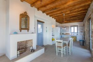 a kitchen and living room with a fireplace and a table at Serifos Stone Villa A in Rámos
