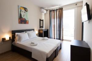 una camera da letto con un letto con lenzuola bianche e una finestra di Modern apt in Glyfada a Breath Away from the Sea - The View ad Atene