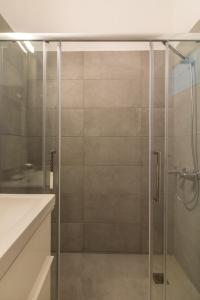 a shower with a glass door in a bathroom at Superb apartment in the heart of Athens in Athens